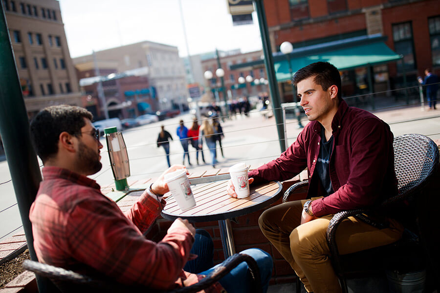 Two students sitting outside coffee shop