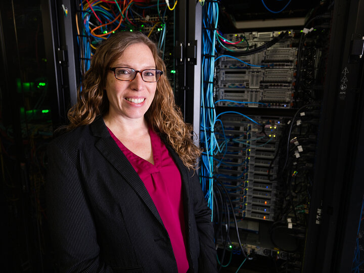 Lori Hoetger standing in front of a server rack