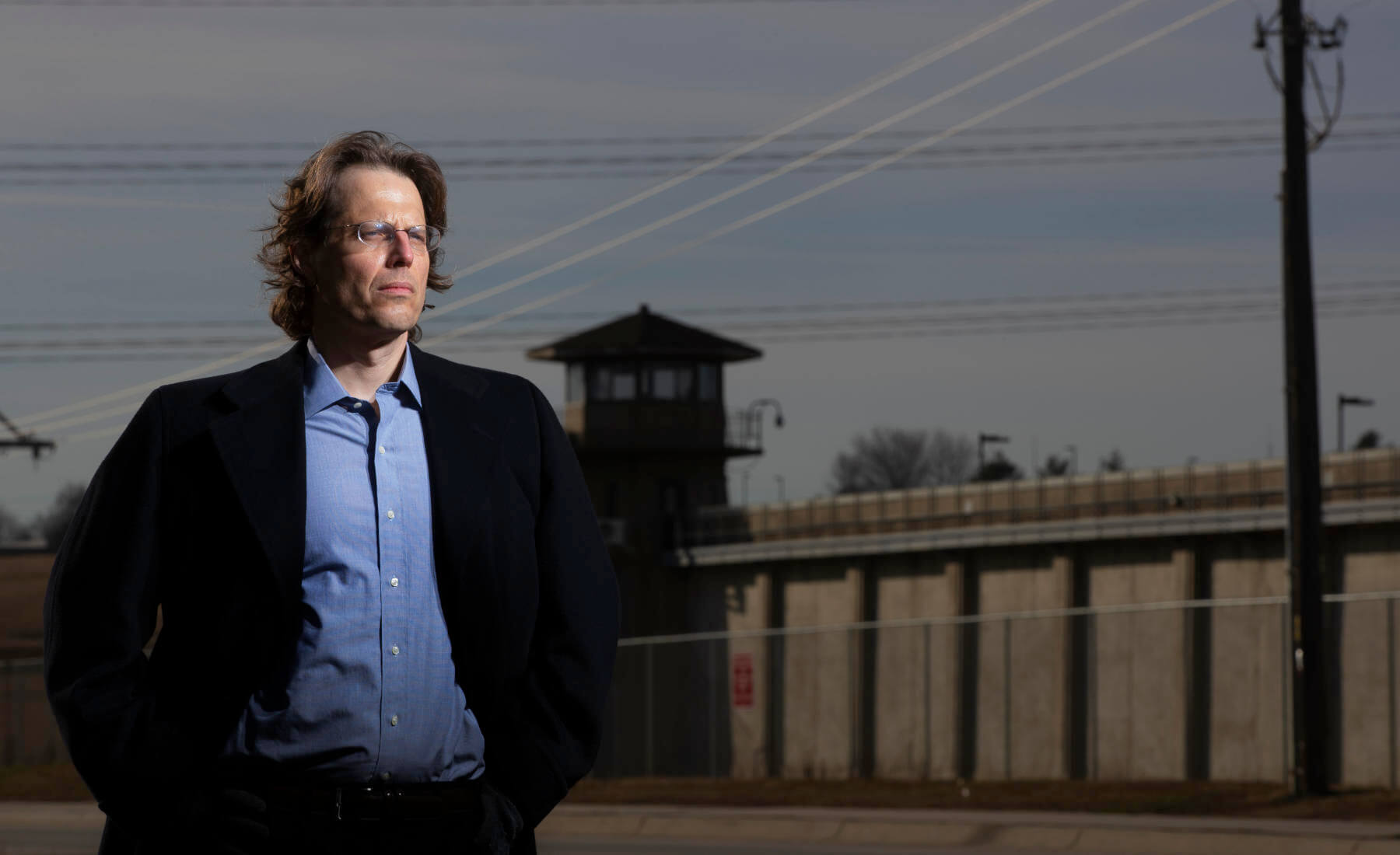 Professor Eric Berger standing in field in front of penitentary