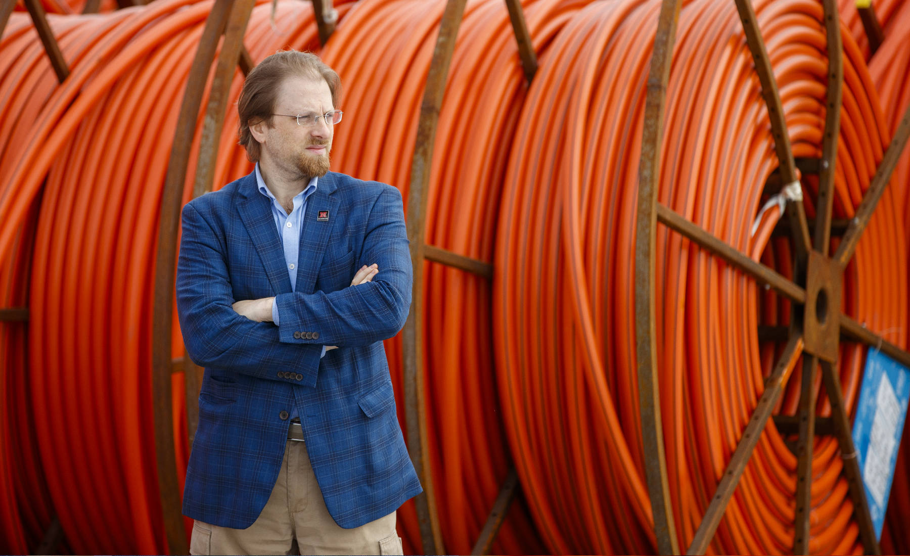 Gus Hurwitz portrait outside with cable spools