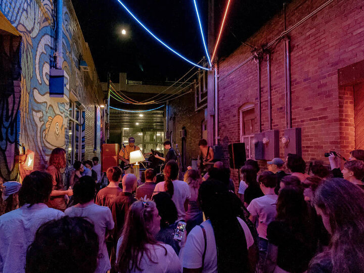 People watching a band play in an alley