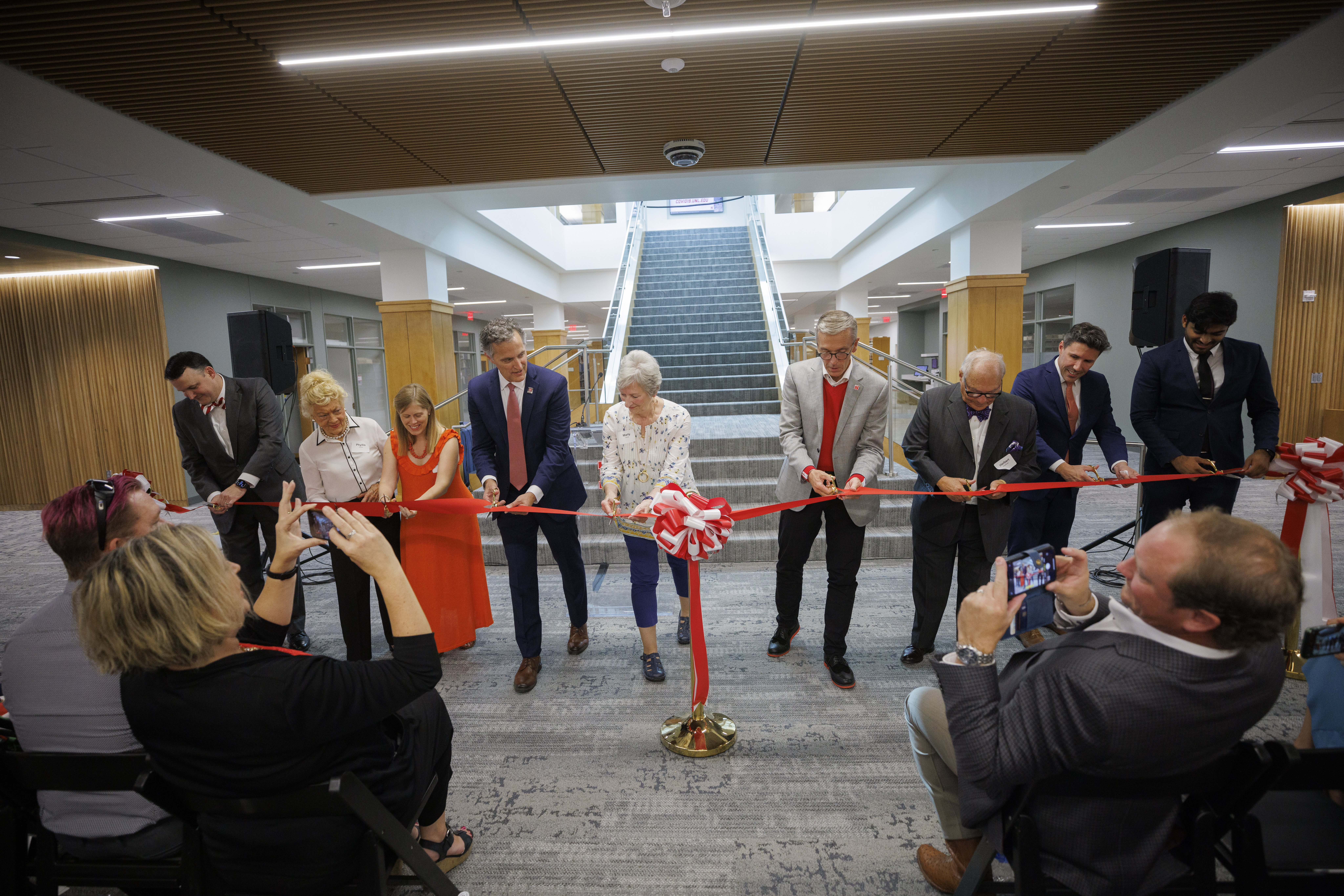 Ronnie Green, Dean Richard Moberly, and others cutting ribbon to the re-opening of the Schmid Library