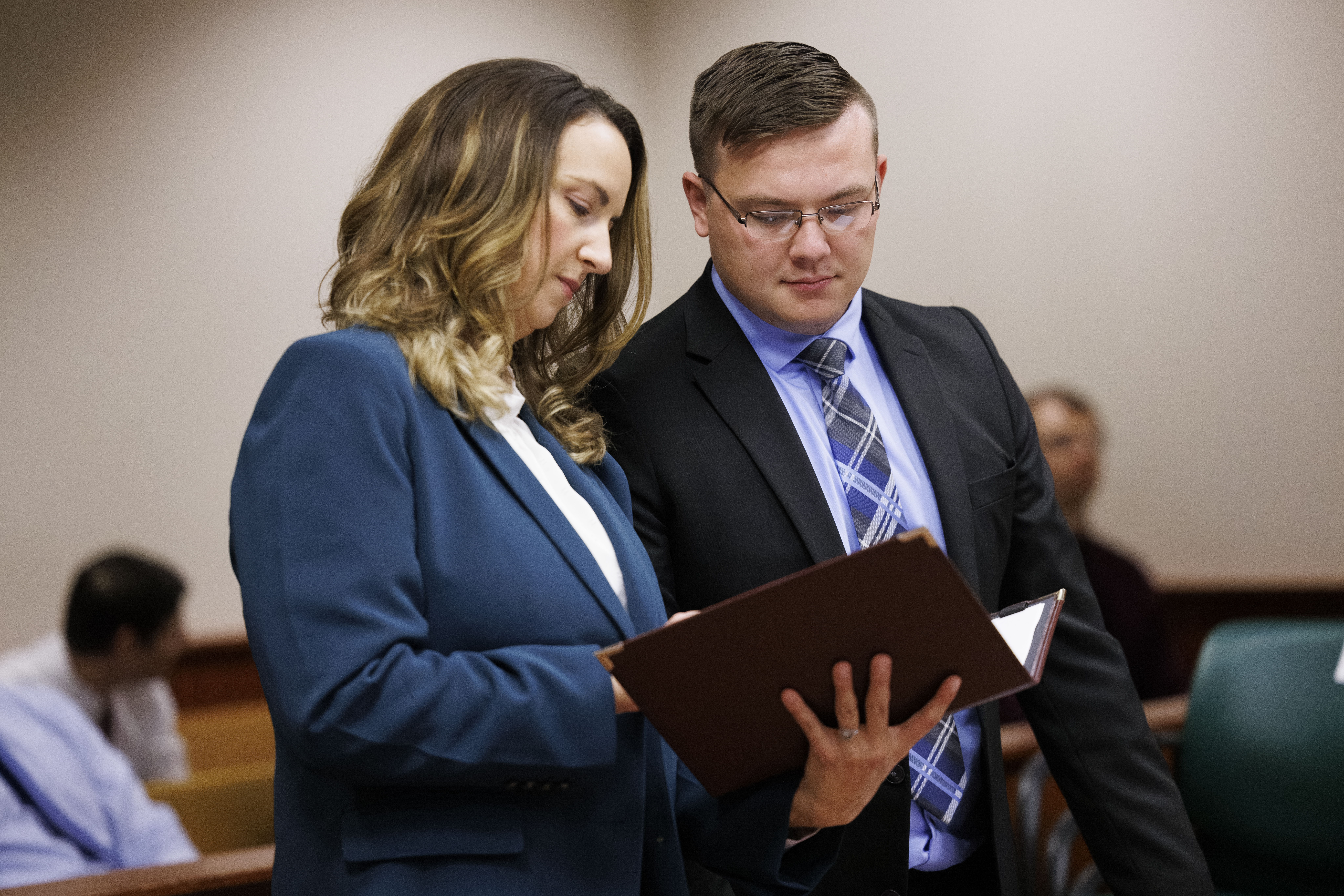 Professor standing with student reviewing a document