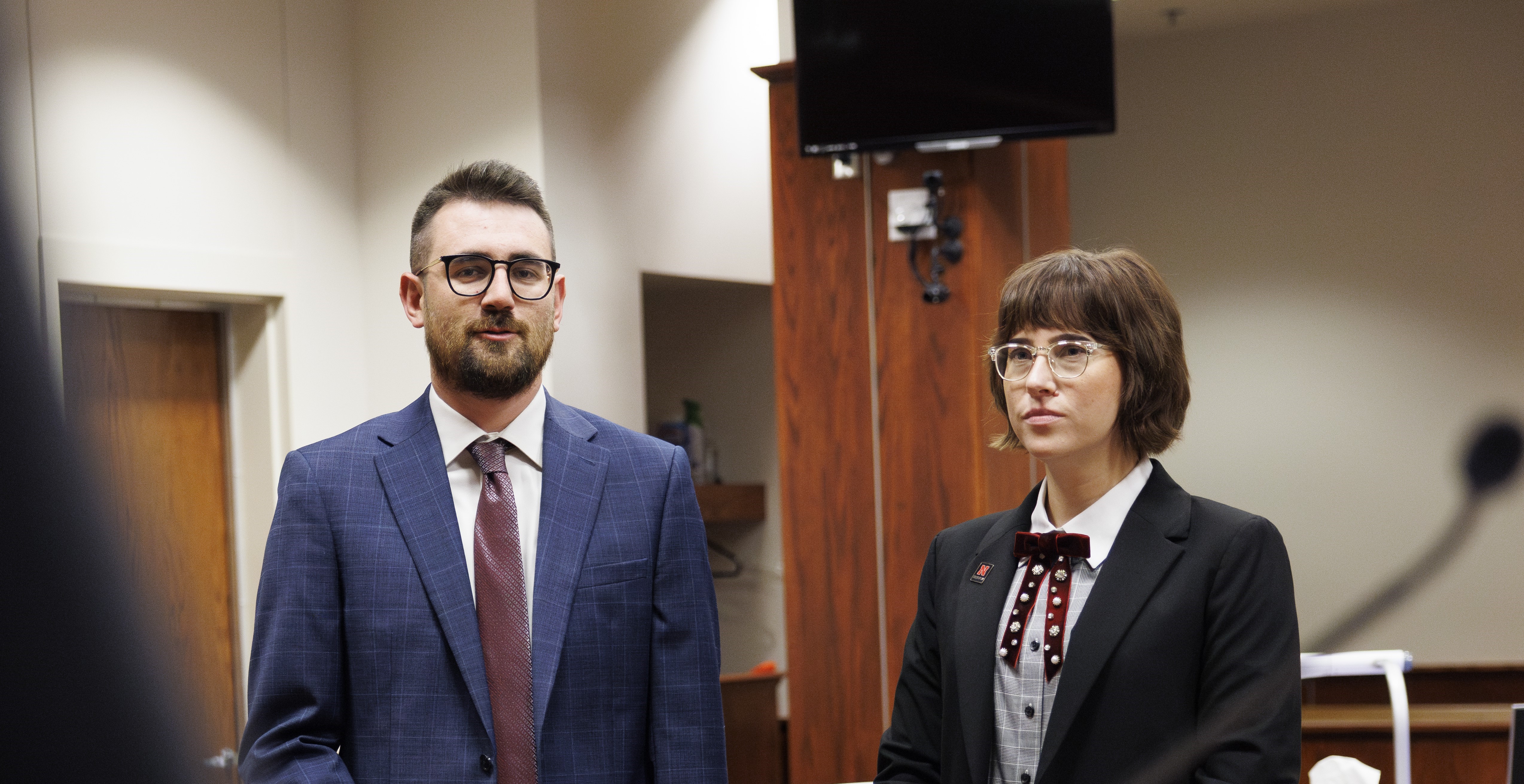 Three people sitting at a desk looking at documents