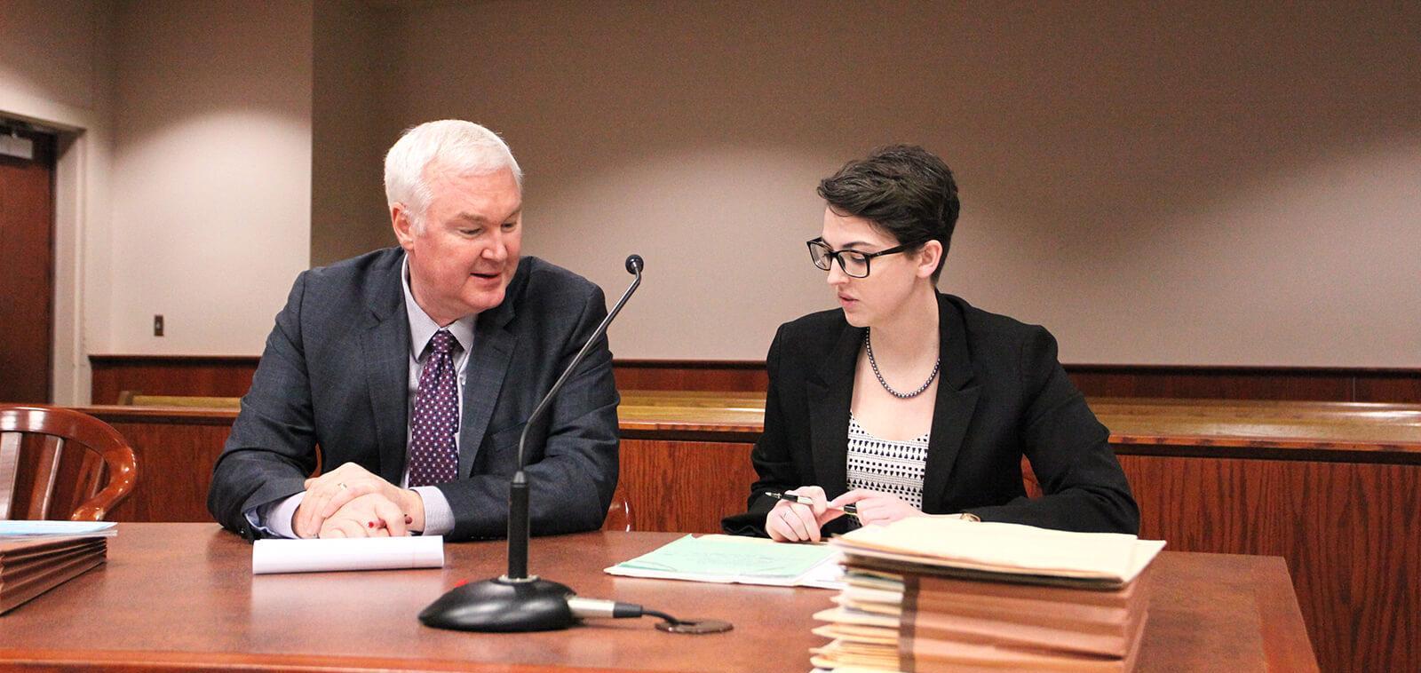 Two people talking at a court table