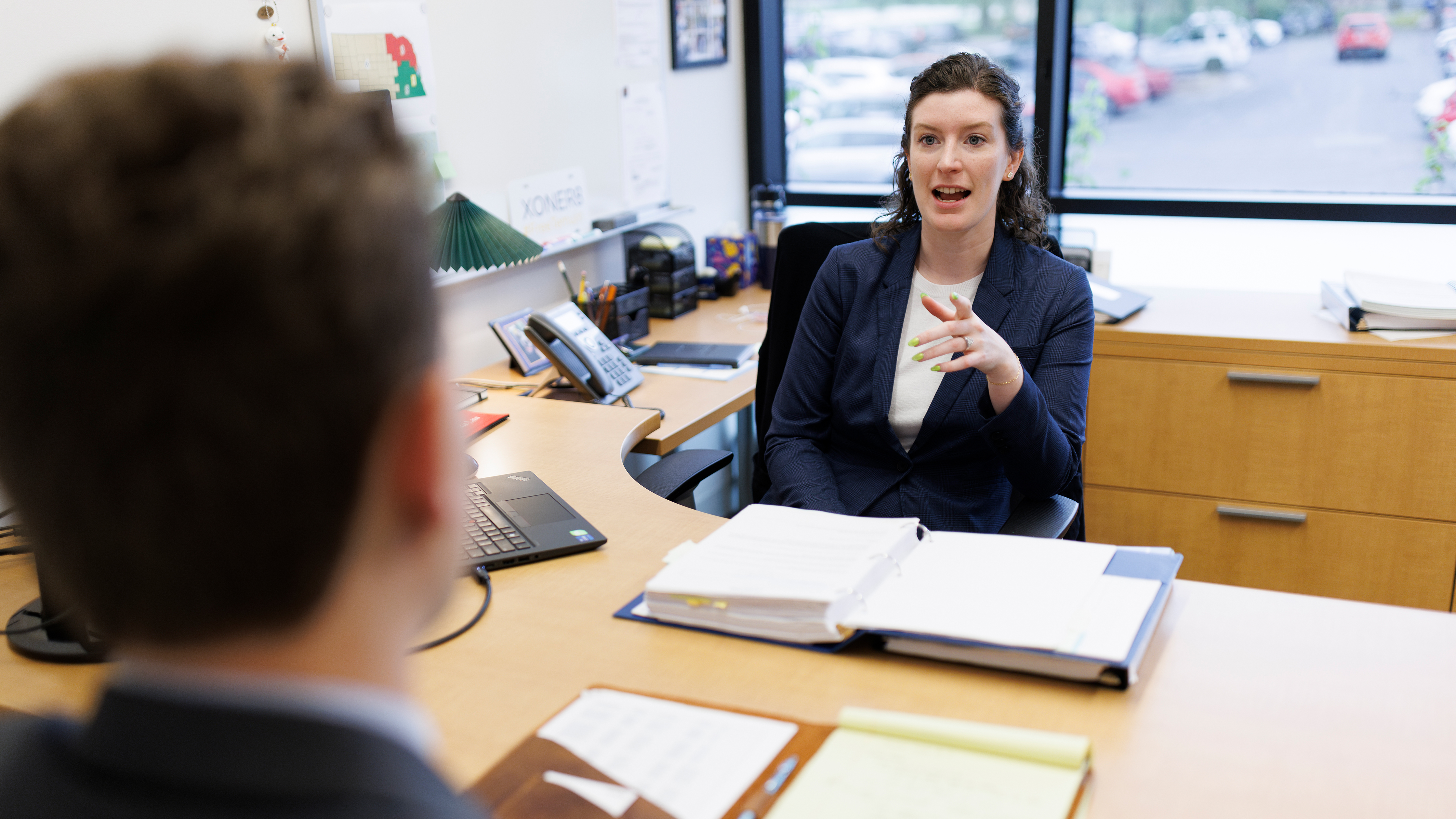 Elizabeth Cole sitting at a desk across from a student