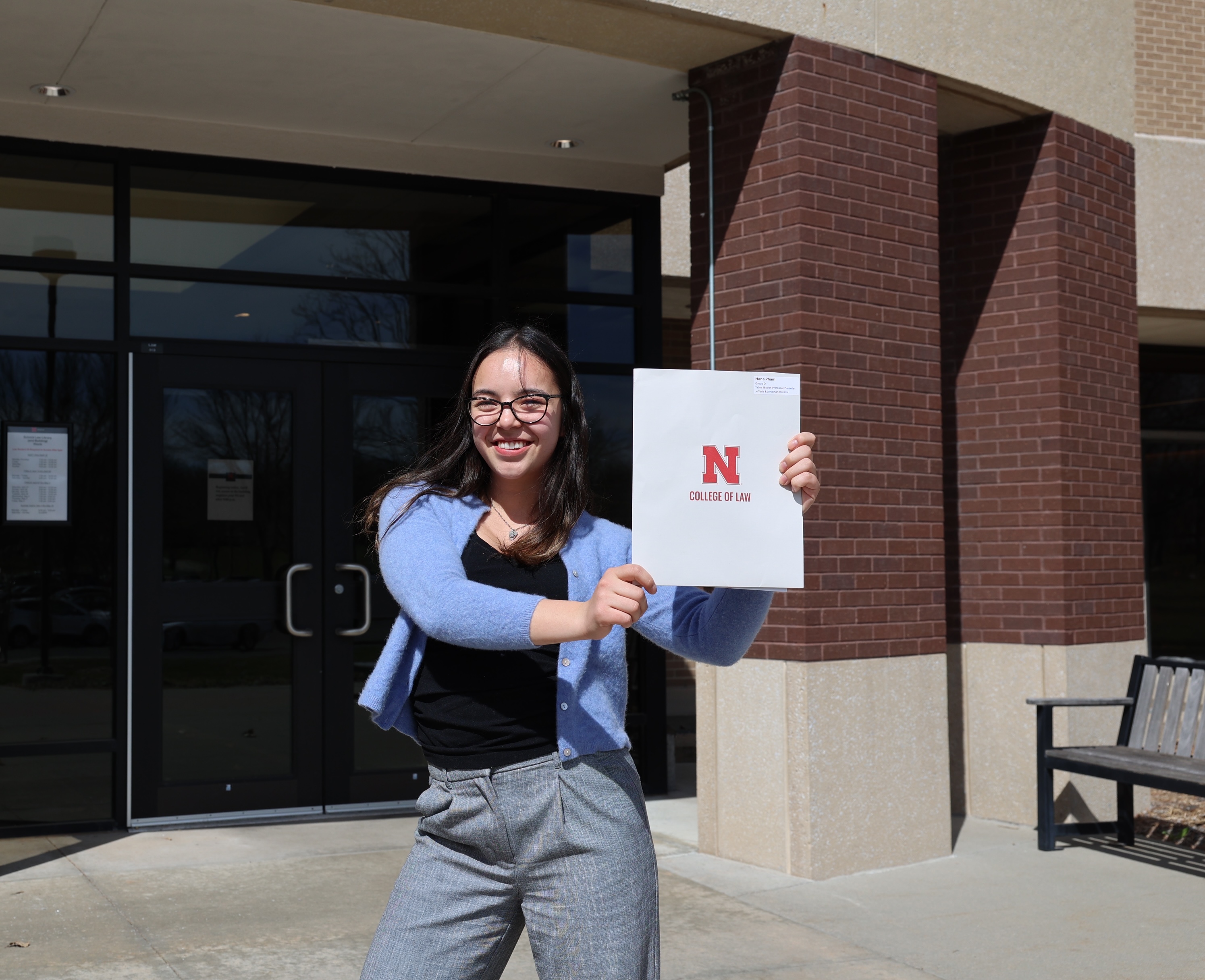 Student holding up folder with Nebraska College of Law logo on it