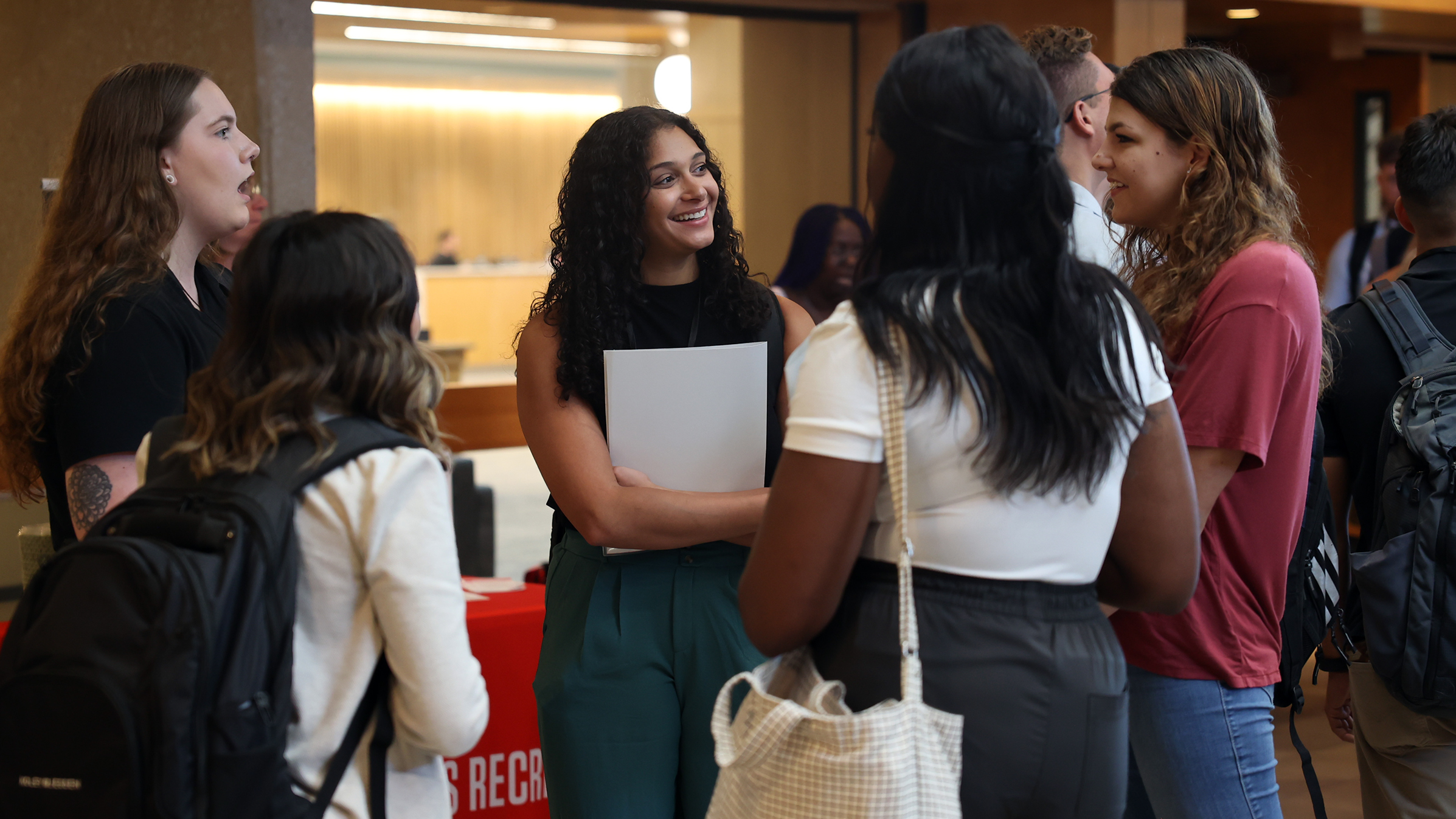 Five female students standing in a group with folders