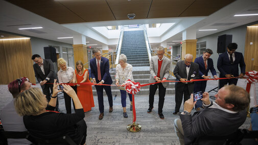 Ronnie Green, Dean Richard Moberly, and others cutting ribbon to the re-opening of the Schmid Library