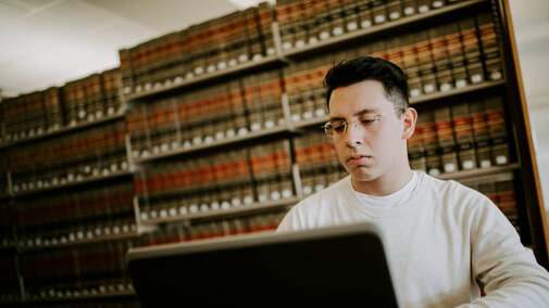 Person with glasses looking at laptop