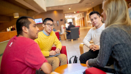 Students sitting on chairs and talking in a circle