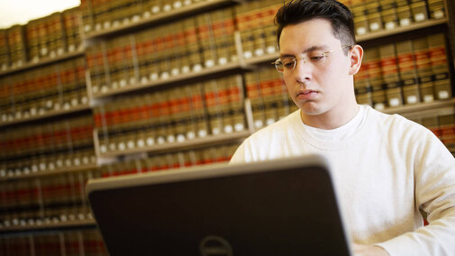 Person looking at laptop in the library