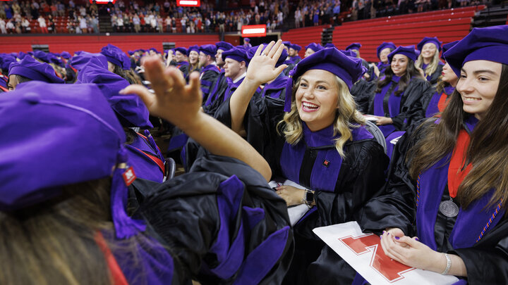 Graduates in robes high-five