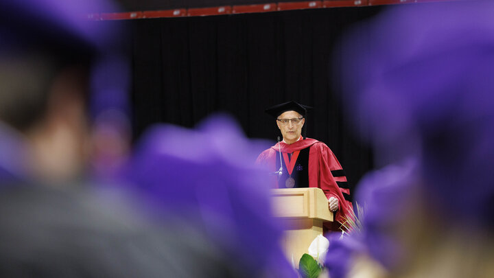 Richard E. Moberly, dean of the University of Nebraska College of Law, speaks to law graduates from a lectern.