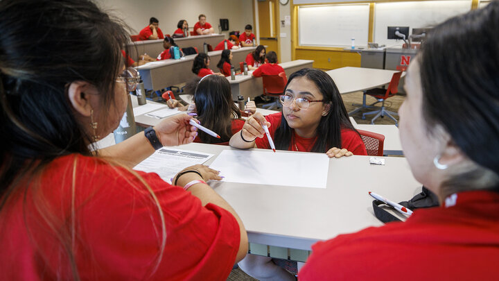 Ana Cortez Martir, a junior from Omaha South High school, works with her team as they develop a business pitch during their session at the College of Business.