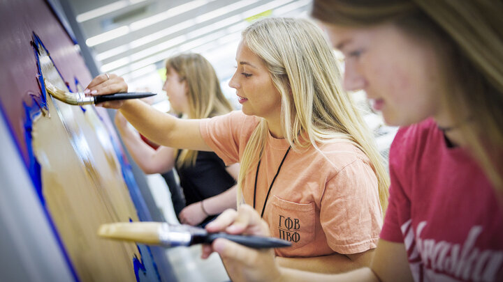 Grace Schleining (middle) and fellow first-year law students paint a mural with mountains in Habitat for Humanity of Lincoln’s ReStore location on Aug. 22. The first-year students participated in the service-learning project as part of their orientation.