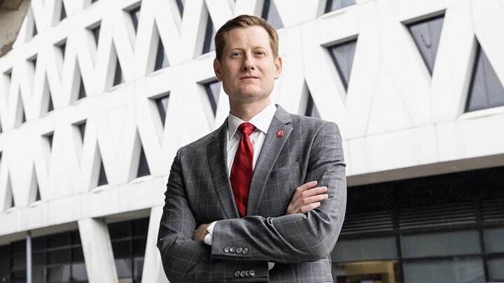 John Cunningham standing with arms crossed