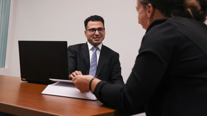 Samer Salman speaks with a client in a meeting room.