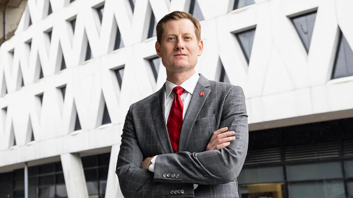 John Cunningham standing with arms crossed