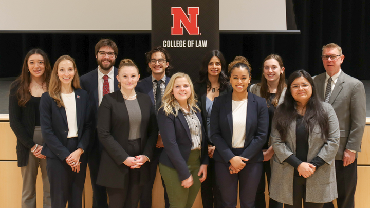 Students pose in front of a Nebraska Law banner with Professor Kevin Ruser