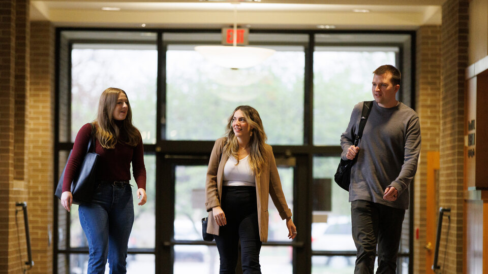 3 students walking in hallway