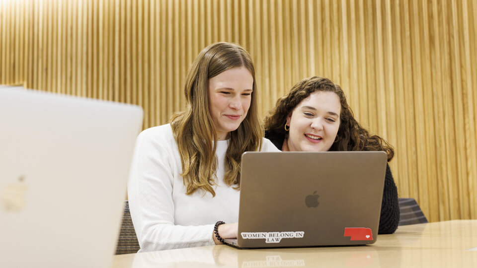 Two students looking at one laptop