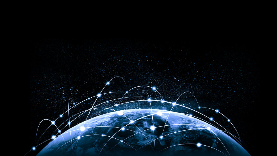 Glowing Earth with connected light trails, representing global network against a starry black sky.