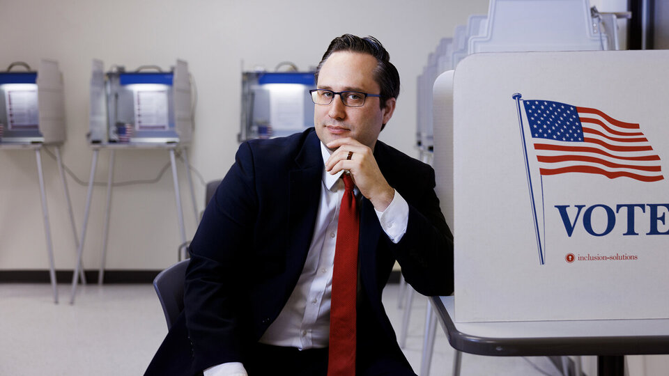 Professor Brandon Johnson sitting at a voting booth