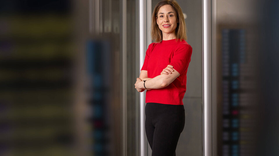 Professor Elana Zeide standing in front of glass doors with subtle light reflection