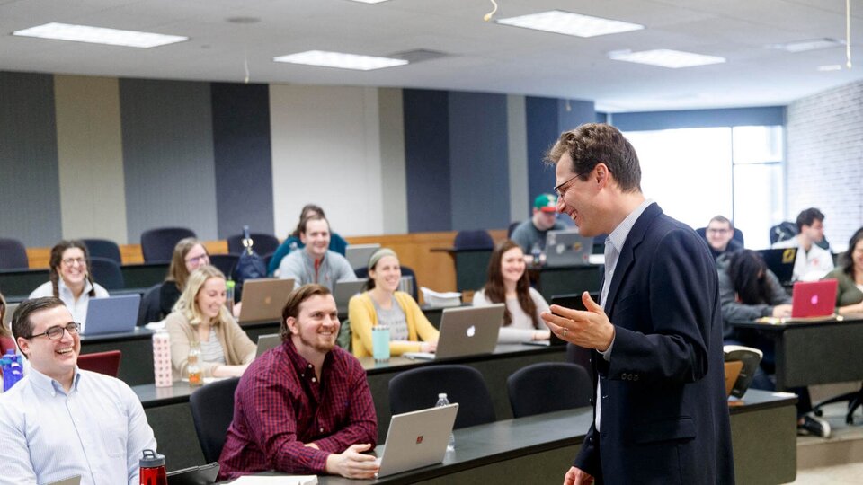 Professor smiling while lecturing students