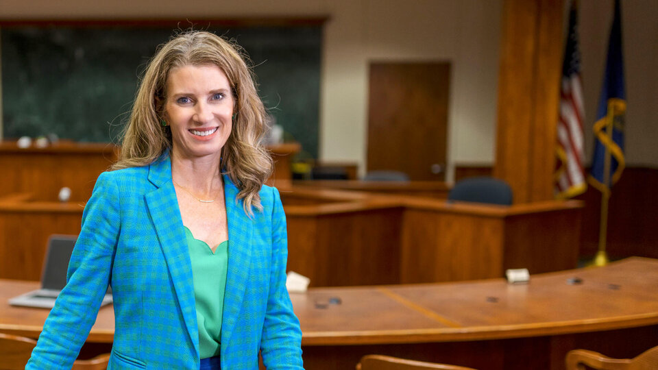 Professor Michelle Paxton smiling and standing in front of court room