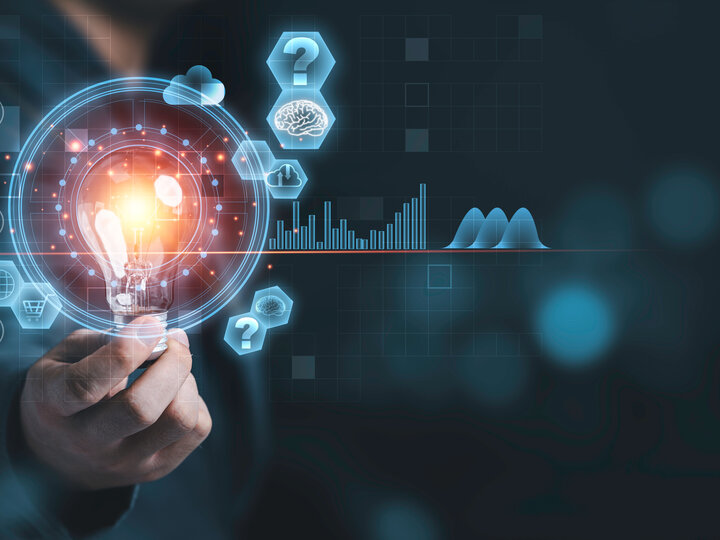 A hand holding a glowing lightbulb surrounded by futuristic digital icons and graphs.