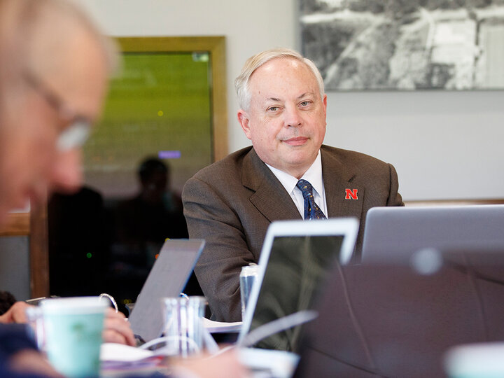 Jack Beard sitting at a table with laptop in front of him with others around him doing the same