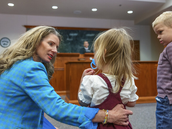 A woman talking with two children.