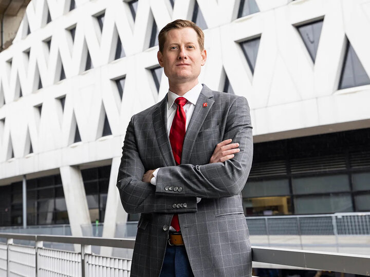 John Cunningham standing with arms crossed