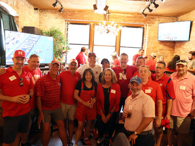 Large group of people wearing Husker apparel and posing for a photo