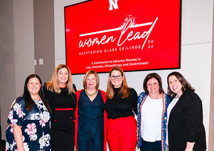 Six women standing under a Women Lead sign