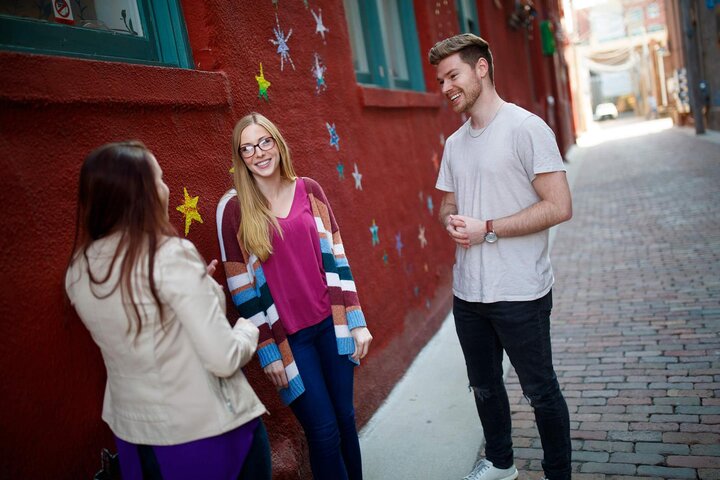 Group of people talking in alleyway with star graphics on the wall