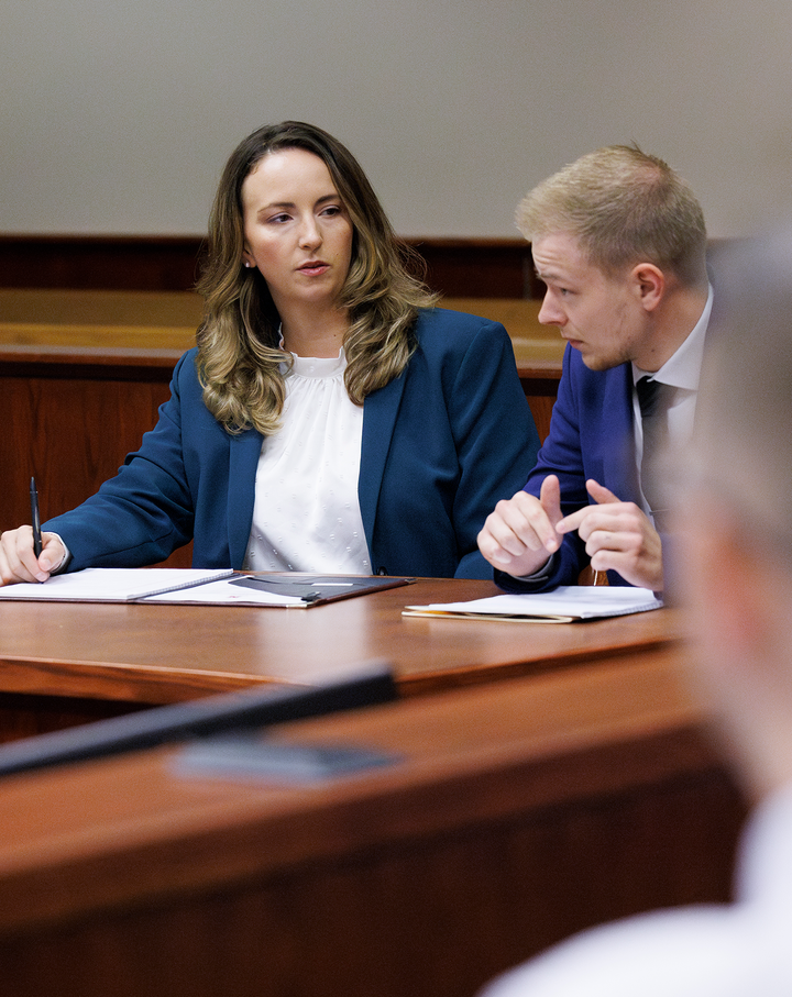 Professor Jessica Murphy speaks to a student in a courtroom