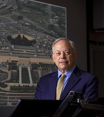 Professor Jack Beard standing in front of a projection screen showing the Pentagon